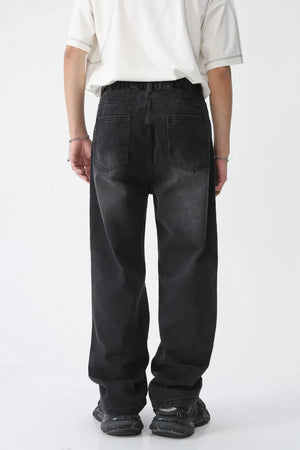Distressed wide-leg denim jeans in dark wash with raw edge hem and classic back pockets.