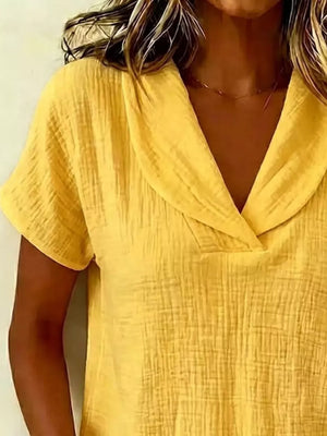 Yellow textured blouse with short sleeves and a V-neck collar.