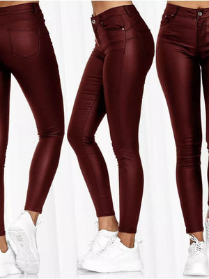 High-waisted red faux-leather skinny pants with a shiny finish.