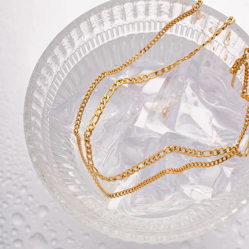 Gold dual-strand curb chain necklace with two distinct link styles.