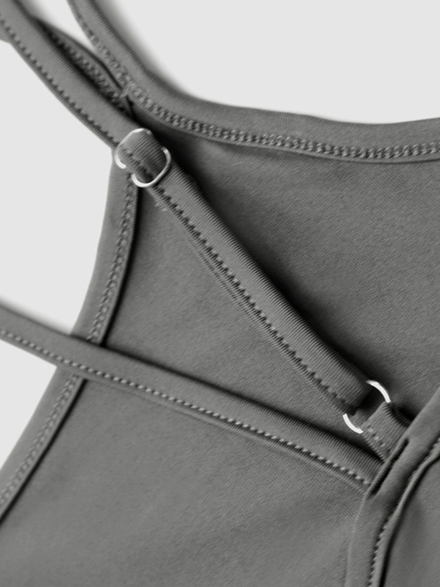 Grey active romper with adjustable straps and metal ring details.