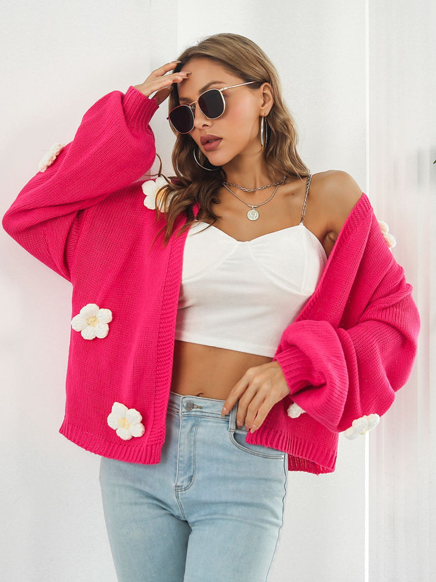 Hot pink knit cardigan with balloon sleeves and floral appliqués.