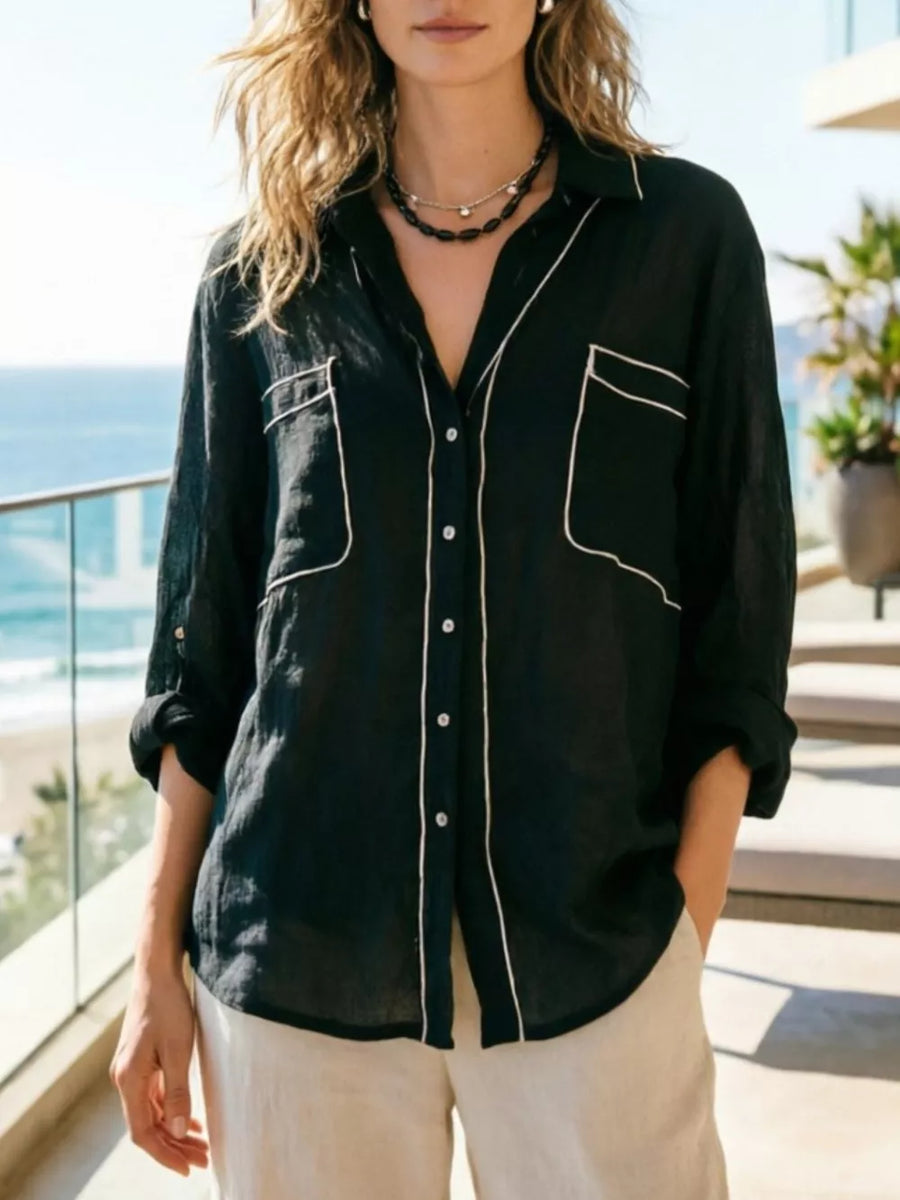 Black linen button-up shirt with white piping, chest pockets, and rolled sleeves.