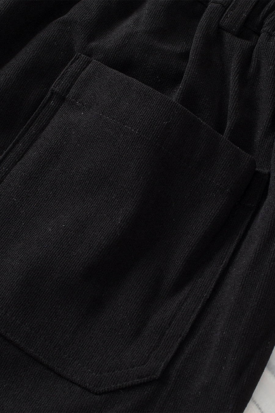 Black seamed front wide leg trousers with a visible pocket detail.