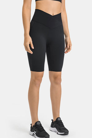 Black V-waist pocketed performance biker shorts with a high rise and mid-thigh length.