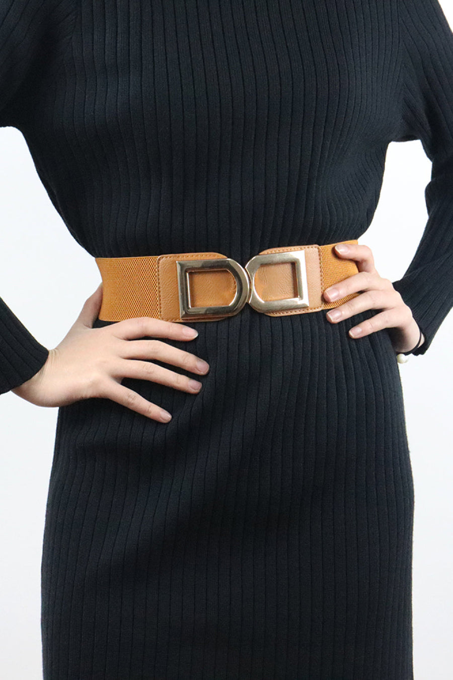 Caramel elastic belt with double buckle detail worn over a black dress