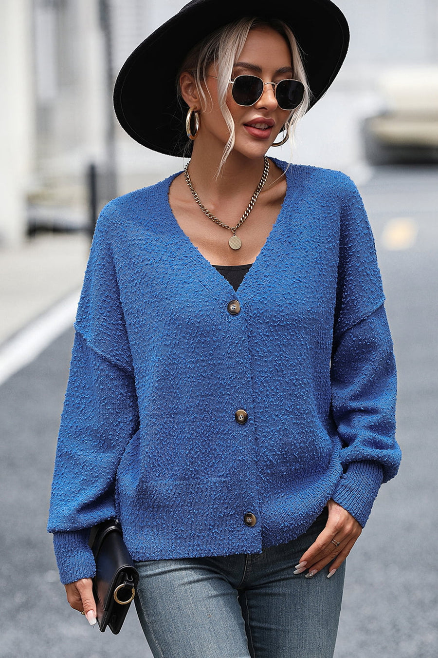 Blue textured bouclé button-down cardigan with V-neck and long sleeves.