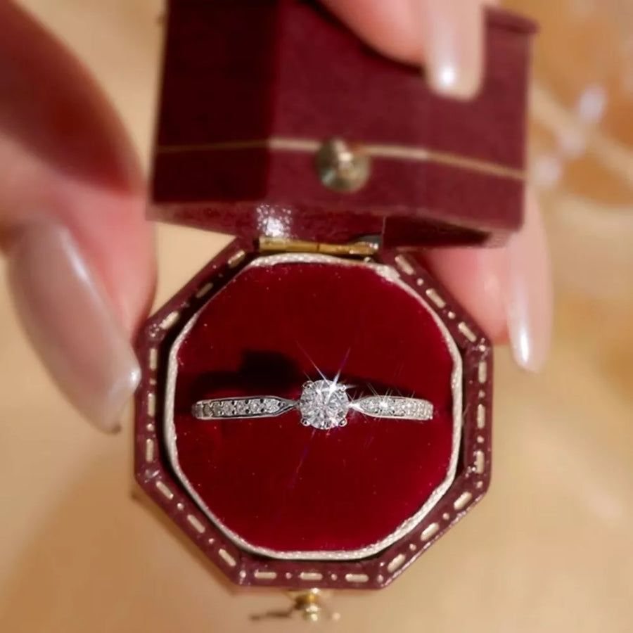 Elegant moissanite ring in sterling silver with a brilliant center stone and pavé band.