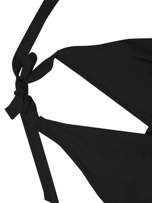 Black backless mini dress with ruffled details and tie straps.