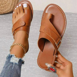 Brown toe ring sandals with buckle detail and adjustable strap.