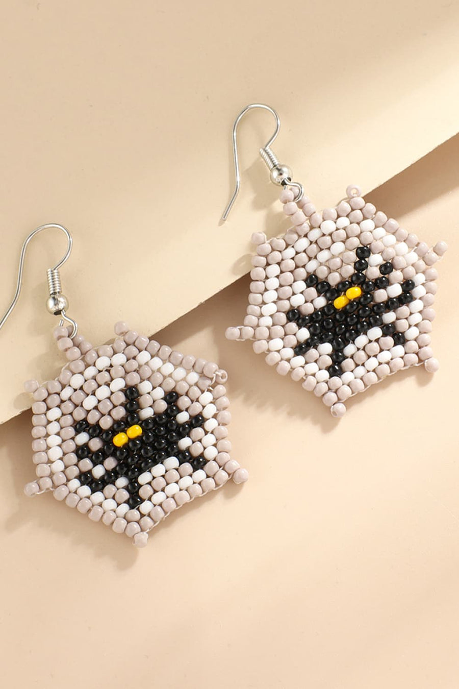 Beaded Black Cat earrings with yellow eyes and a grey, white, and black patchwork design.