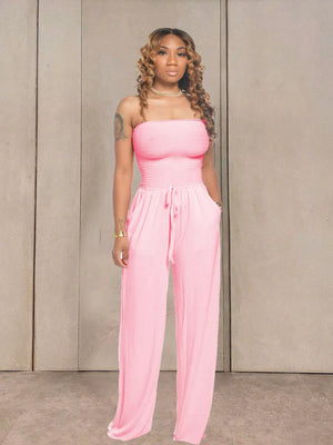 Pink smocked strapless jumpsuit with wide legs and drawstring waist