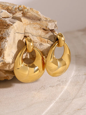 Gold sculpted statement earrings with a polished finish and oval shape.
