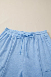 Light blue knit jogger pants with drawstring waist and pockets.