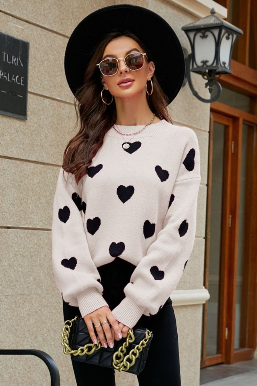 Beige and black heart jacquard knit sweater with balloon sleeves and crew neck.