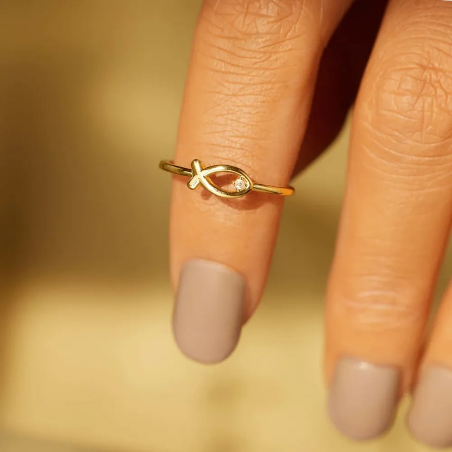 Gold fish motif ring with zircon detail on a finger