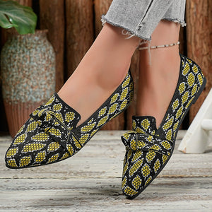 Yellow abstract print slip-on flats with knot detail and pointed toe.