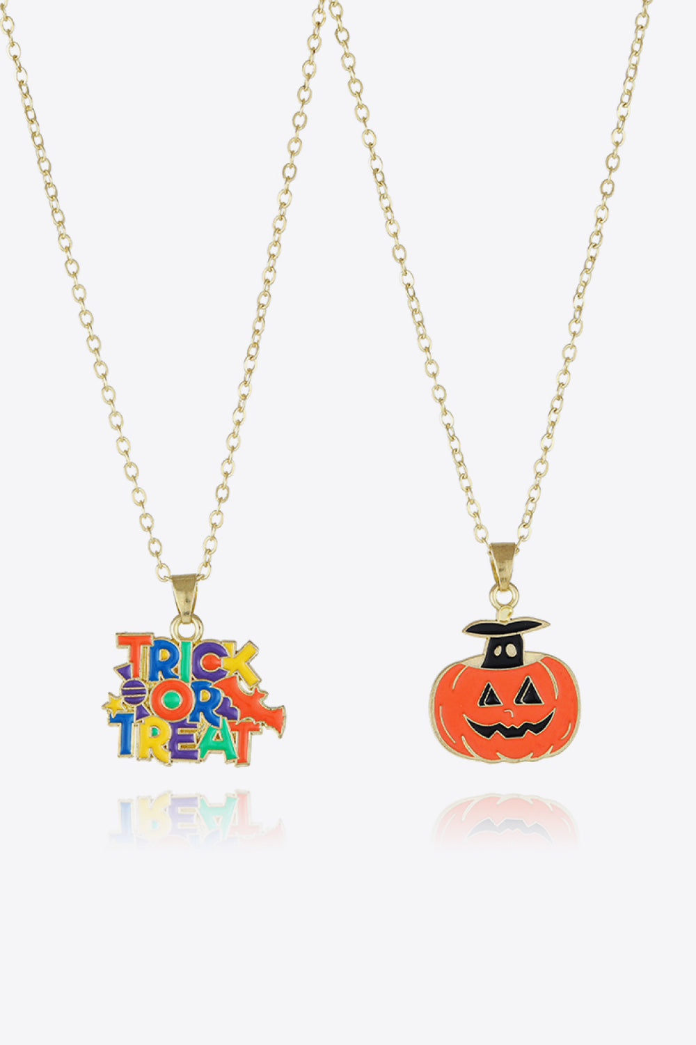 Spooky season enamel pendant necklaces with trick or treat text and jack-o-lantern charms.