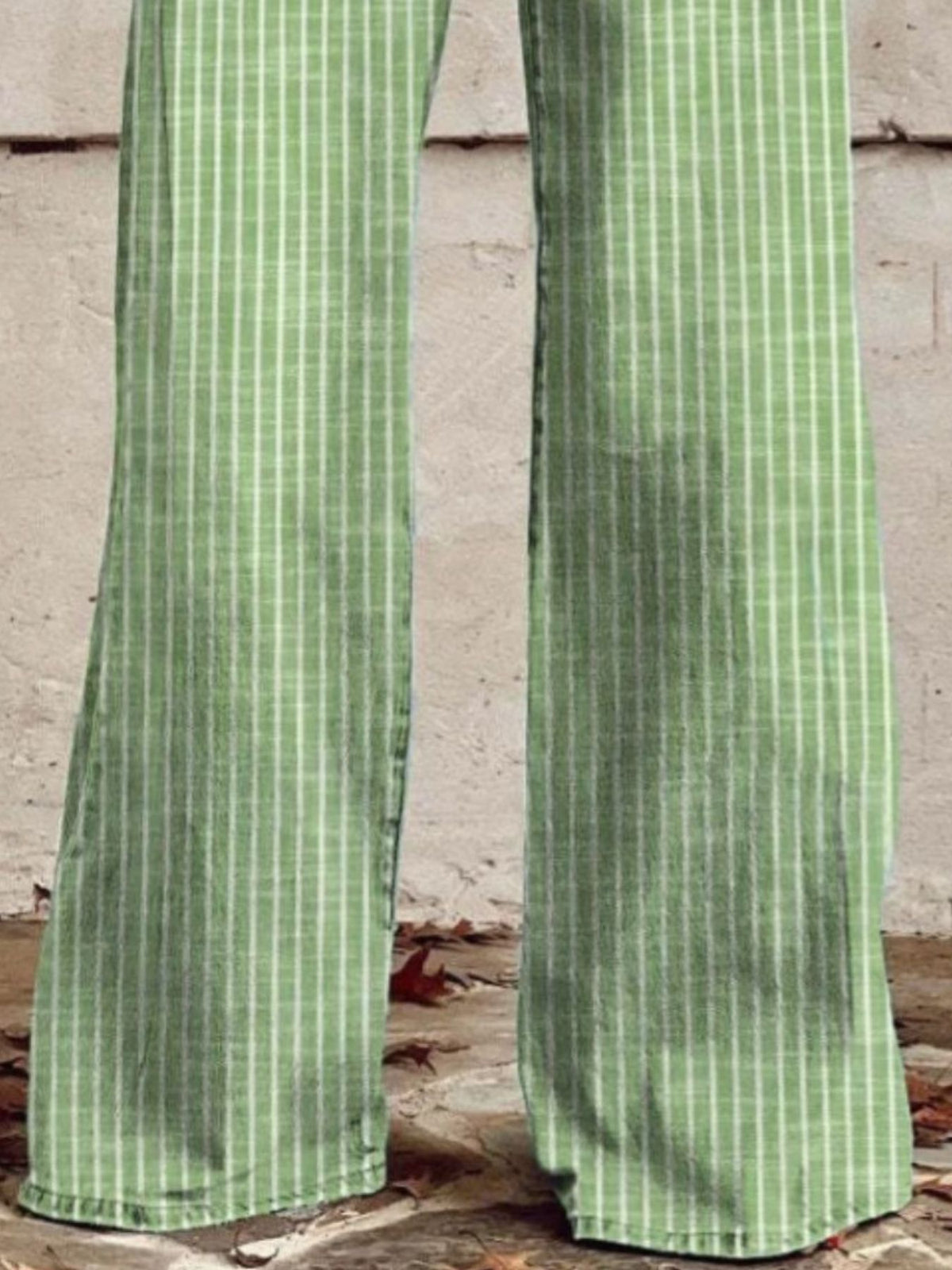 Green high-waisted wide-leg jeans with white vertical stripes and pockets.