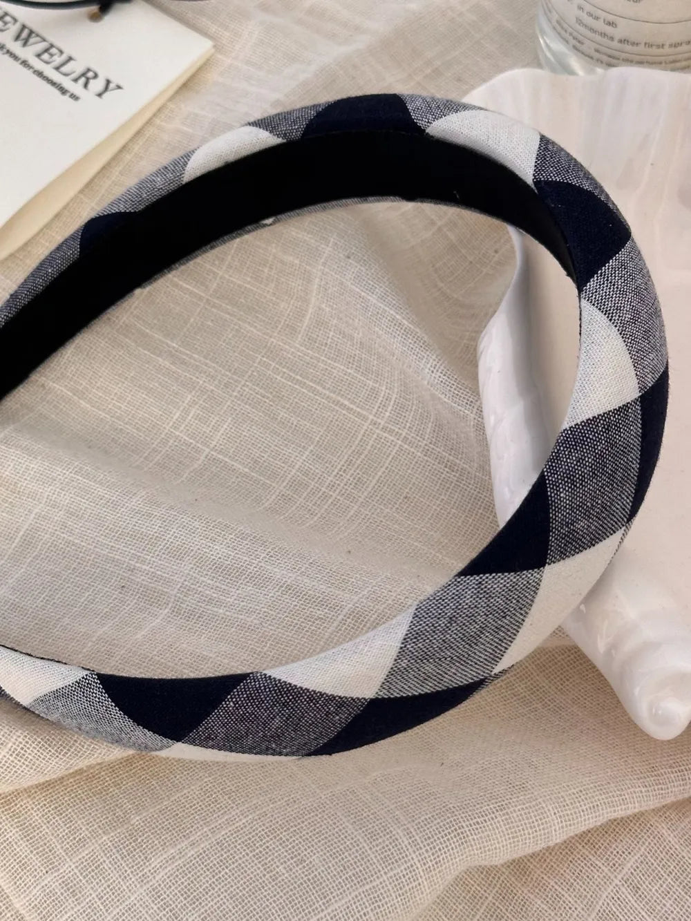 Padded gingham headband in black and white checkered pattern.