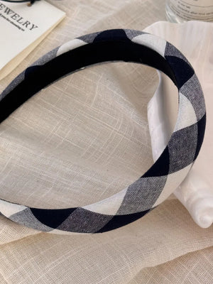 Padded gingham headband in black and white checkered pattern.
