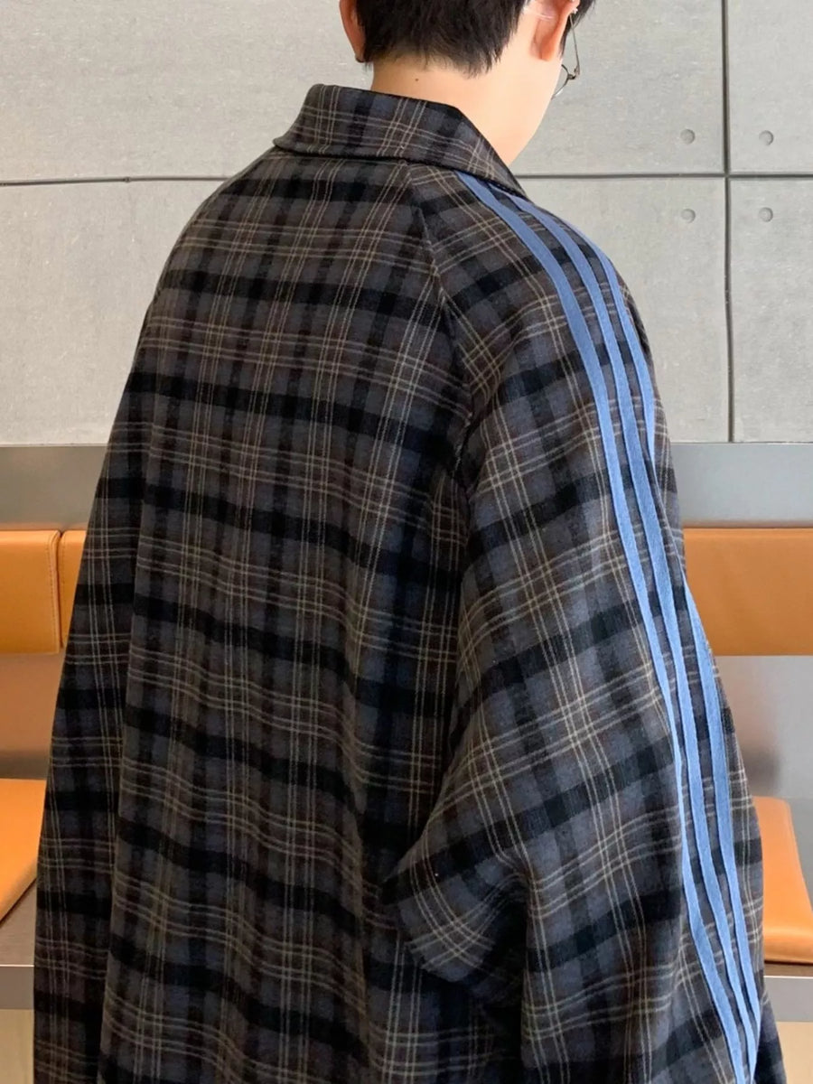 Oversized plaid long-sleeve shirt in black with blue stripes on the sleeves.