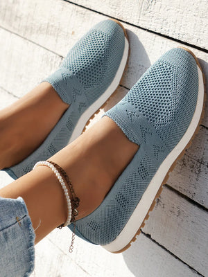 Light blue breathable knit slip-on sneakers with diamond pattern detail.