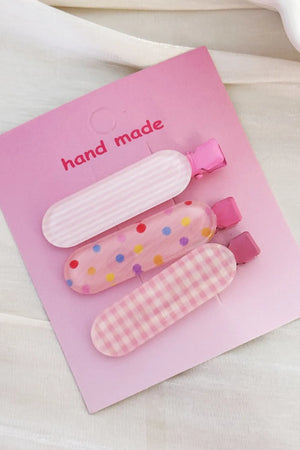 Pastel pink hair clips trio with stripes, polka dots, and gingham patterns.