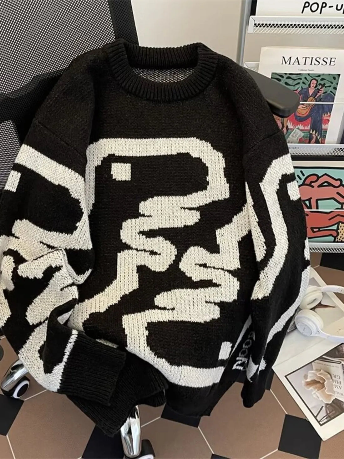 Black oversized sweater with abstract white pattern, ribbed hem and crew neck.