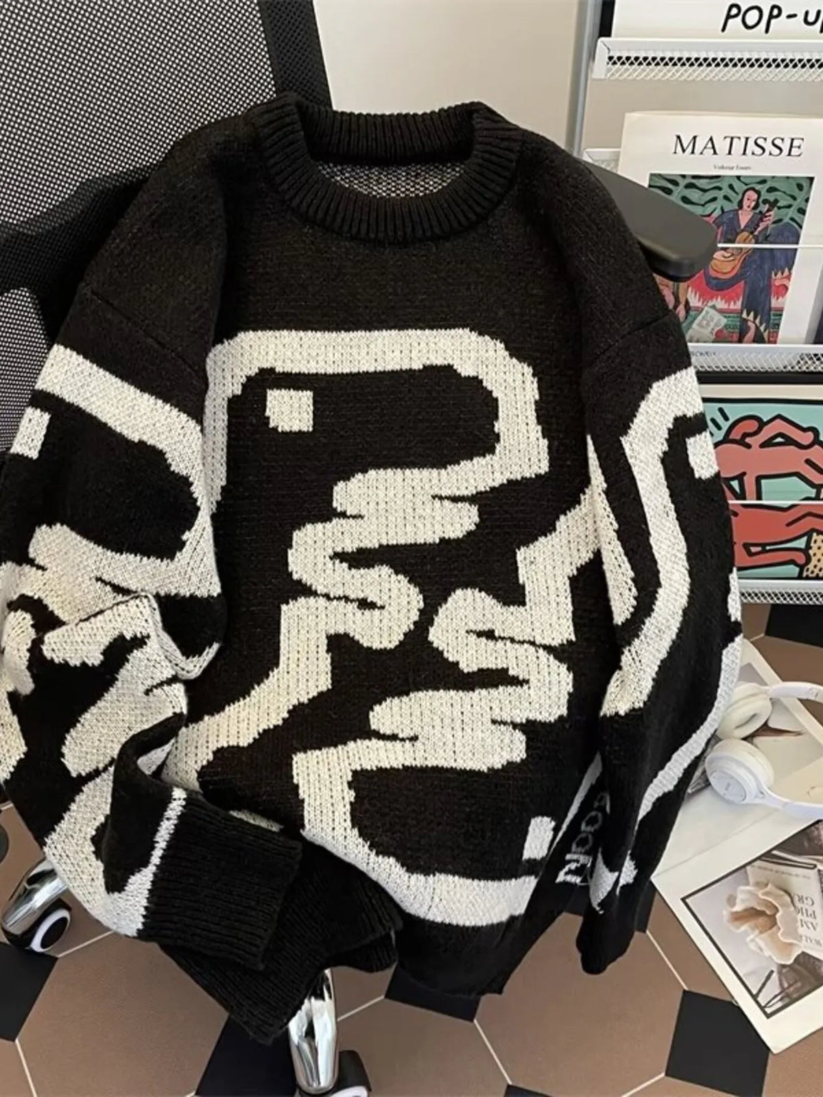 Black oversized sweater with abstract white pattern, ribbed hem and crew neck.