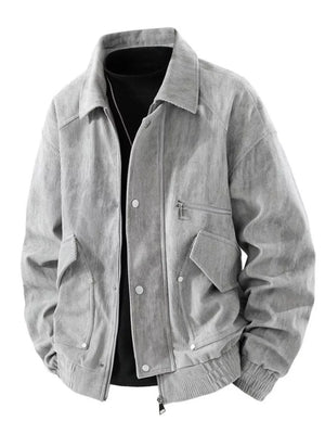 Grey corduroy trucker jacket with buttoned pockets and zip closure.