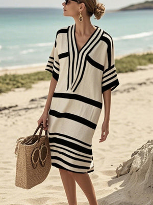 Striped half sleeve midi dress in black and tan with V-neck, worn on the beach.