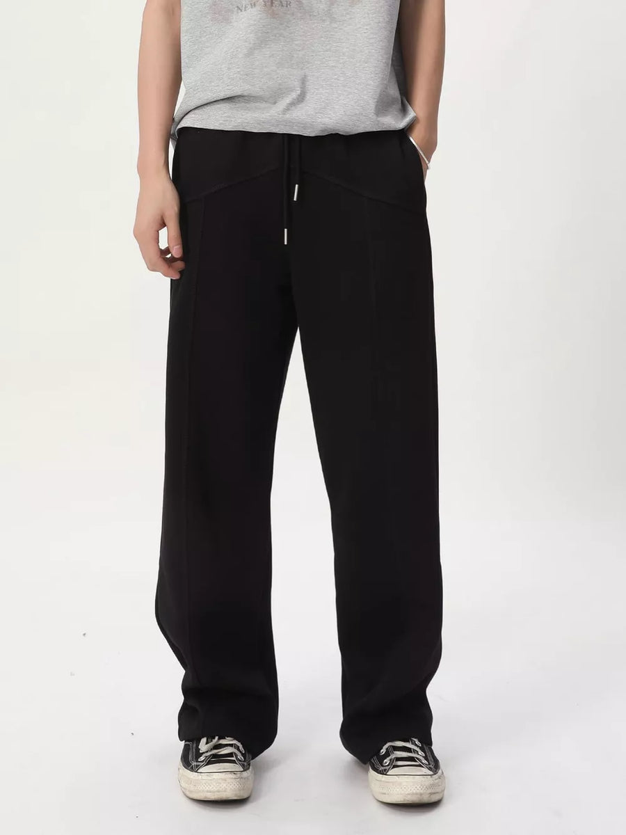 Black cotton drawstring sweatpants with wide legs and tailored seams.