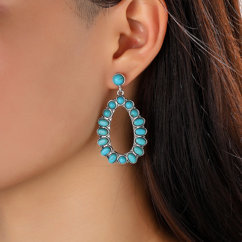 Turquoise teardrop statement earrings with oval turquoise stones and silver alloy setting.