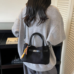 handbag in black featuring top handles and structured fit