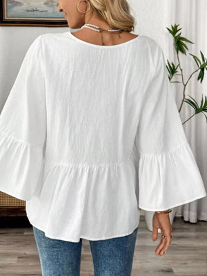 White cotton V-neck blouse with bell sleeves and peplum hem.