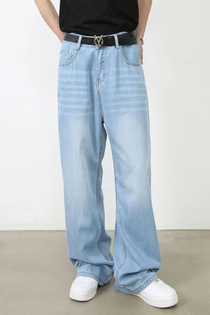 Light blue denim palazzo jeans with a relaxed fit and wide leg, styled with a black belt.