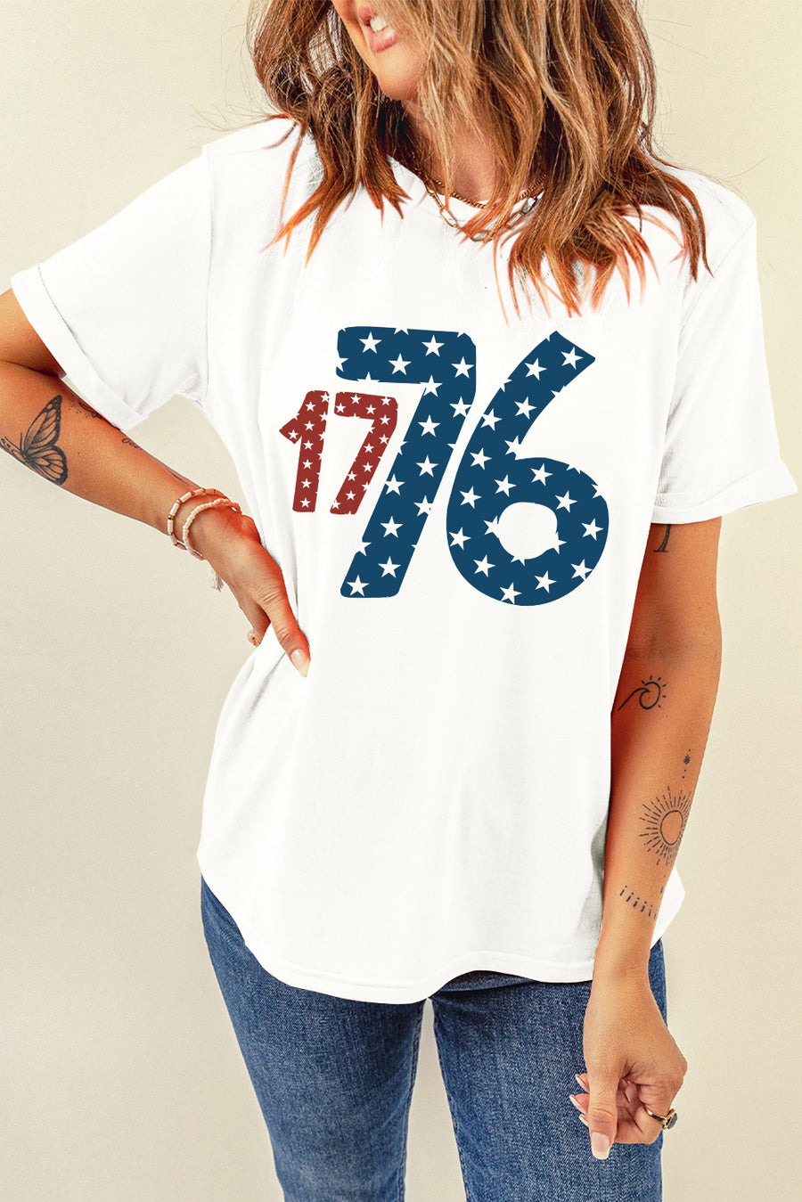 White graphic tee with patriotic 1776 star print, crew neck, short sleeves.