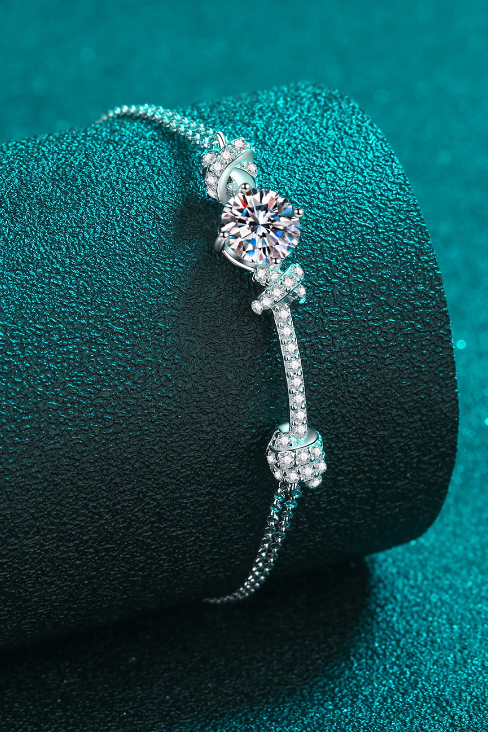 Silver bracelet with cubic zirconia charms and a central diamond-like stone.