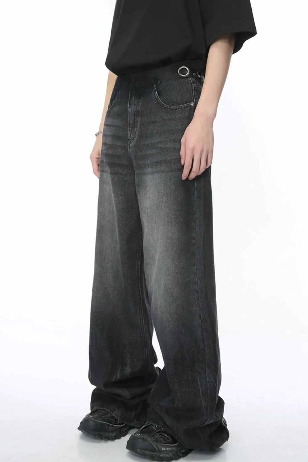 Dark wash denim palazzo trousers with a wide leg and metal ring detail at the waist.