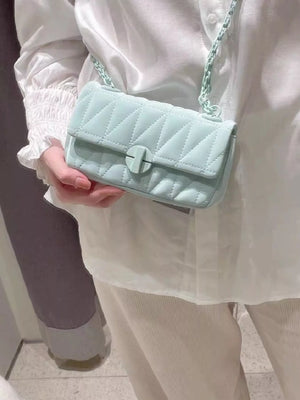 Mini quilted flap chain bag in light green with a turn-lock closure and crossbody strap.