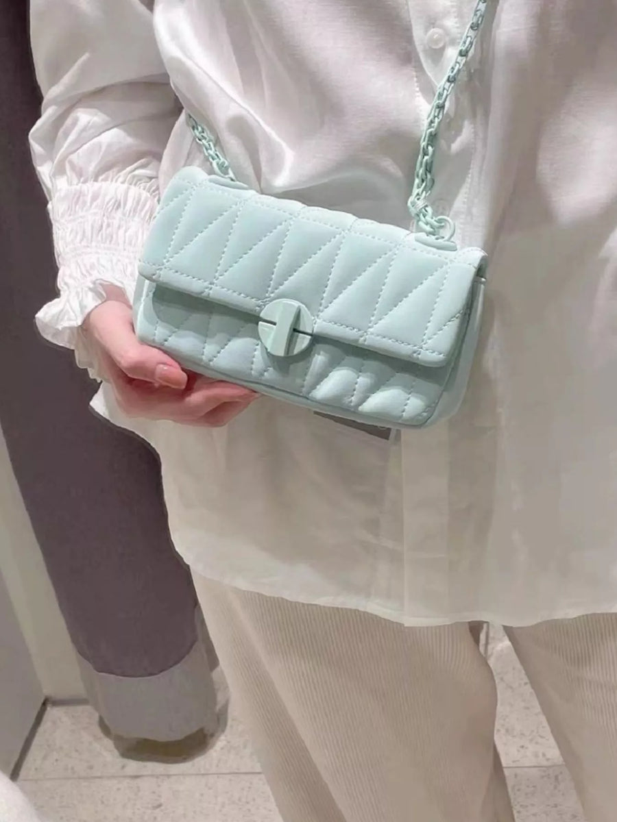 Mini quilted flap chain bag in light green with a turn-lock closure and crossbody strap.