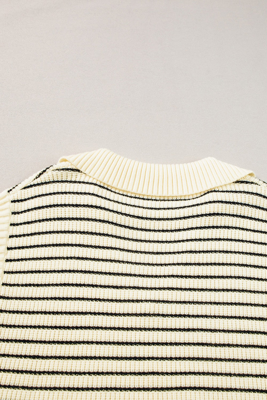 Ivory and black striped knit polo vest with ribbed collar detail.