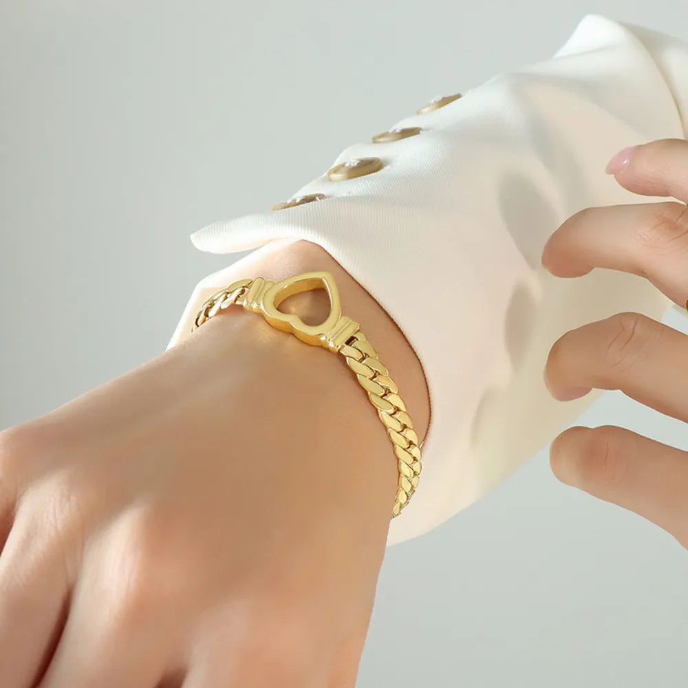 Gold curb chain bracelet with heart link detail, 18K gold-plated.