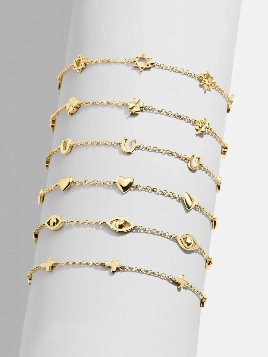 Gold charm chain bracelets with star, clover, horseshoe, heart, evil eye, and cross charms