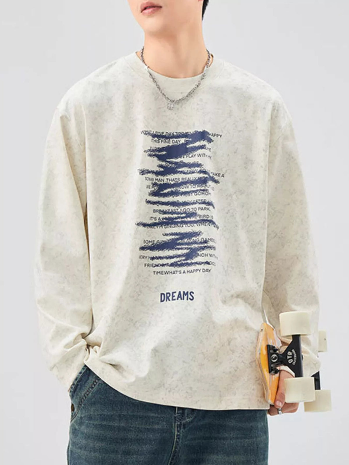 Oversized long-sleeve tee in Apricot with blue graphic text and "DREAMS" print.