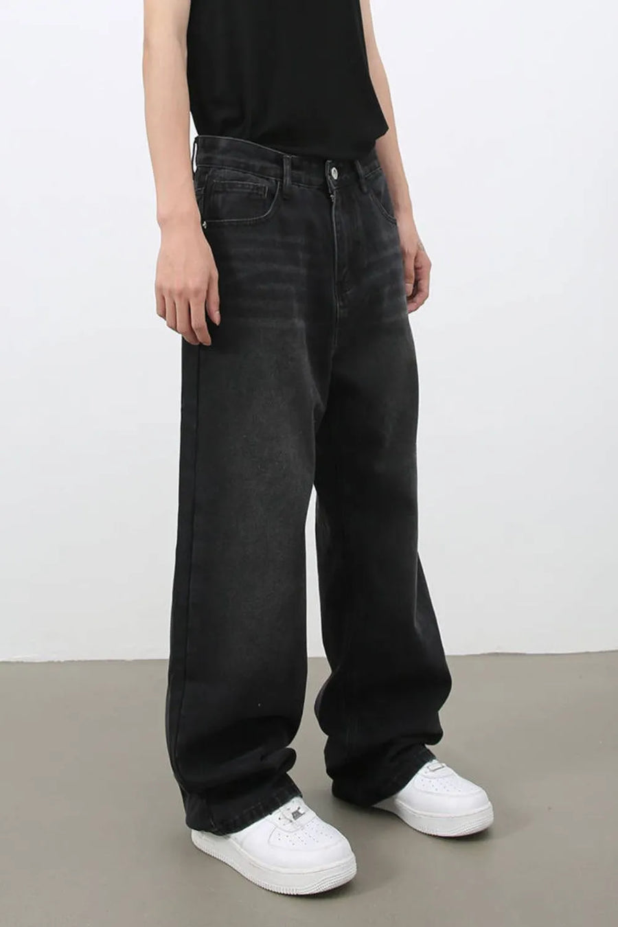 Black wide leg denim jeans with a relaxed fit and subtle whiskering detail.