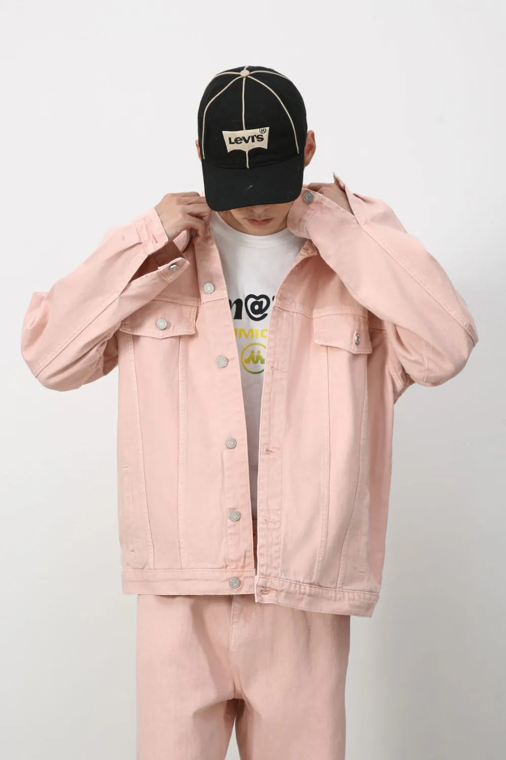 Blush pink denim trucker jacket with button front and chest pockets.