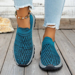 Cerulean knit slip-on sneakers with black chevron pattern and grey soles.