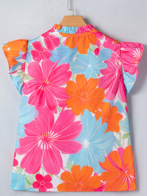 Tie neck ruffle blouse with bright floral print in pink, orange, and blue.